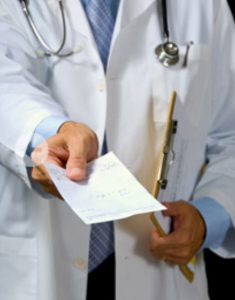 Picture of doctor handing a patient a script